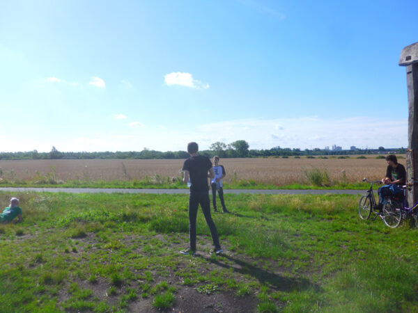 Blick übers Wartenberger Feld mit drei Figuren davor