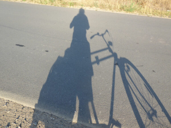 Schatten des Radfahrers auf der Strasse